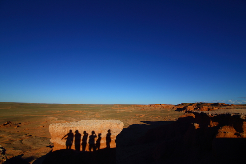 gruppo di turisti si fotografano  al tramonto sulle falesie di  Flaming Cliffs nel deserto del Gobi in Mongolia